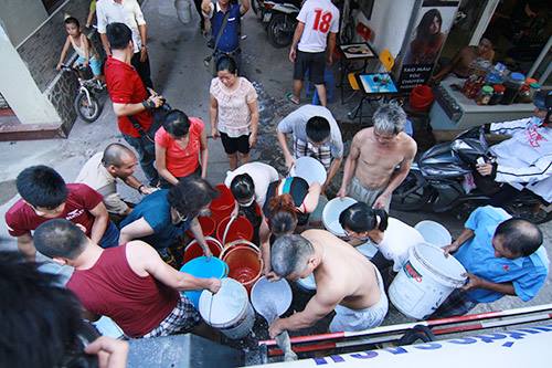 Ảnh: Nam Nguyễn (Chiều 21/8/2015, người dân trong ngõ 814 đường Láng (Đống Đa) chia nhau từng xô nước)