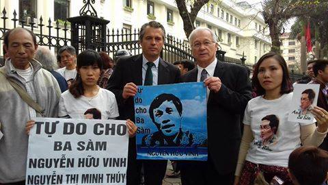 Nghị sĩ Đức Martin Patzelt (người đứng bên phải, đang cầm poster ông Nguyễn Hữu Vinh) trước phiên tòa. Nguồn ảnh: FB Bạch Hồng Quyền