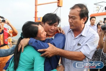 Thuyền trưởng Phạm Phú Thành (ở giữa) trong vòng tay người thân khi trở về đất liền. Ảnh: Hoàng Tuấn 