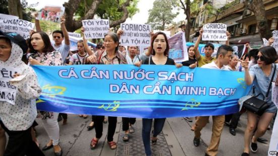 Người dân Việt Nam xuống đường tuần hành với biểu ngữ "Cá cần nước sạch, dân cần minh bạch” tại Hà Nội. Ảnh: EPA