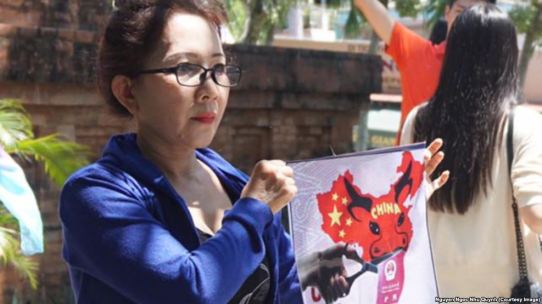 Người biểu tình giơ cao hình ảnh về bản đồ tuyên bố chủ quyền gần như toàn bộ biển Đông của Trung Quốc, hay còn được gọi là “đường lưỡi bò”. Ảnh: FB Nguyễn Ngọc Như Quỳnh.