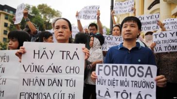 Người biểu tình xuống đường tại Hà Nội với biểu ngữ phản đối công ty Đài Loan Formosa Plastic thải chất độc ra biển làm cá chết hàng loạt tại các tỉnh miền Trung, ngày 1/5/2016. Ảnh: EPA